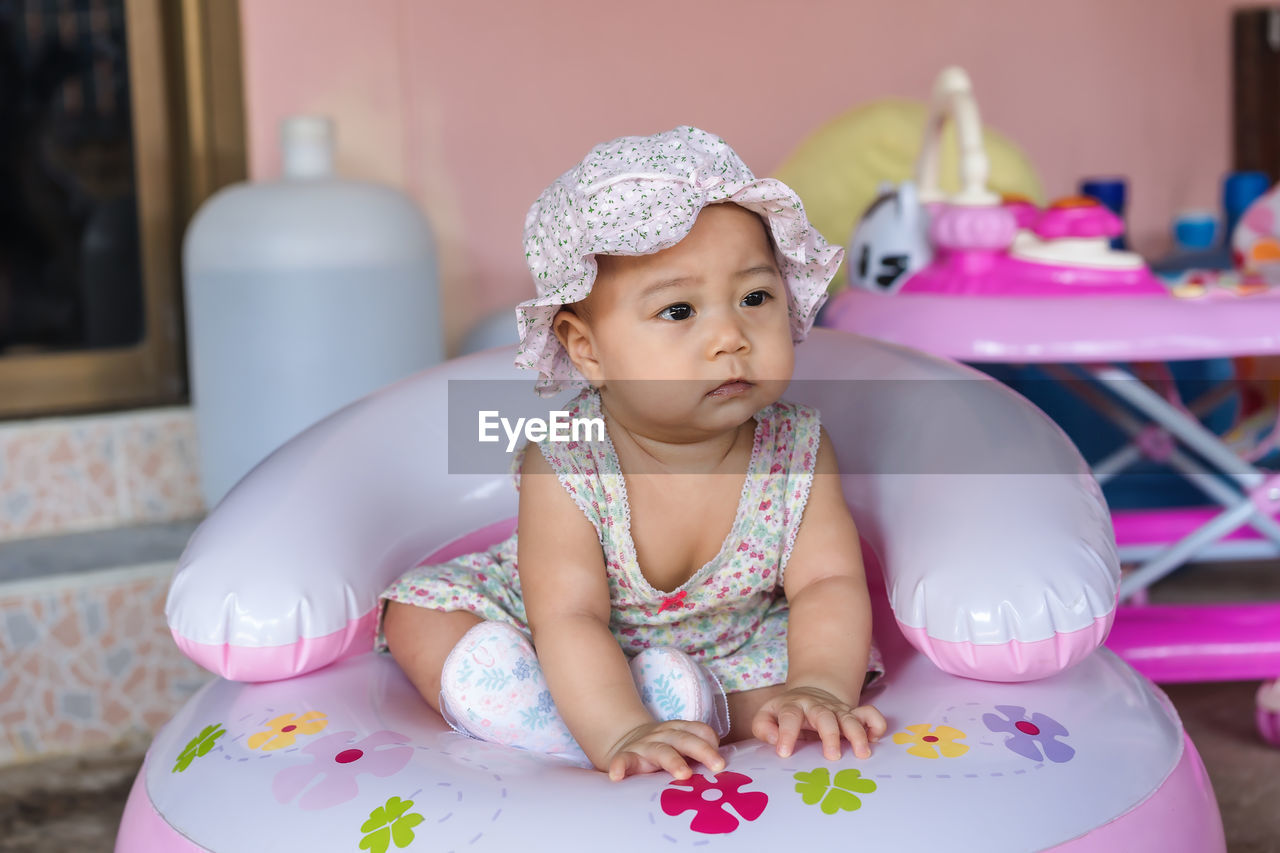 Cute baby girl sitting on table