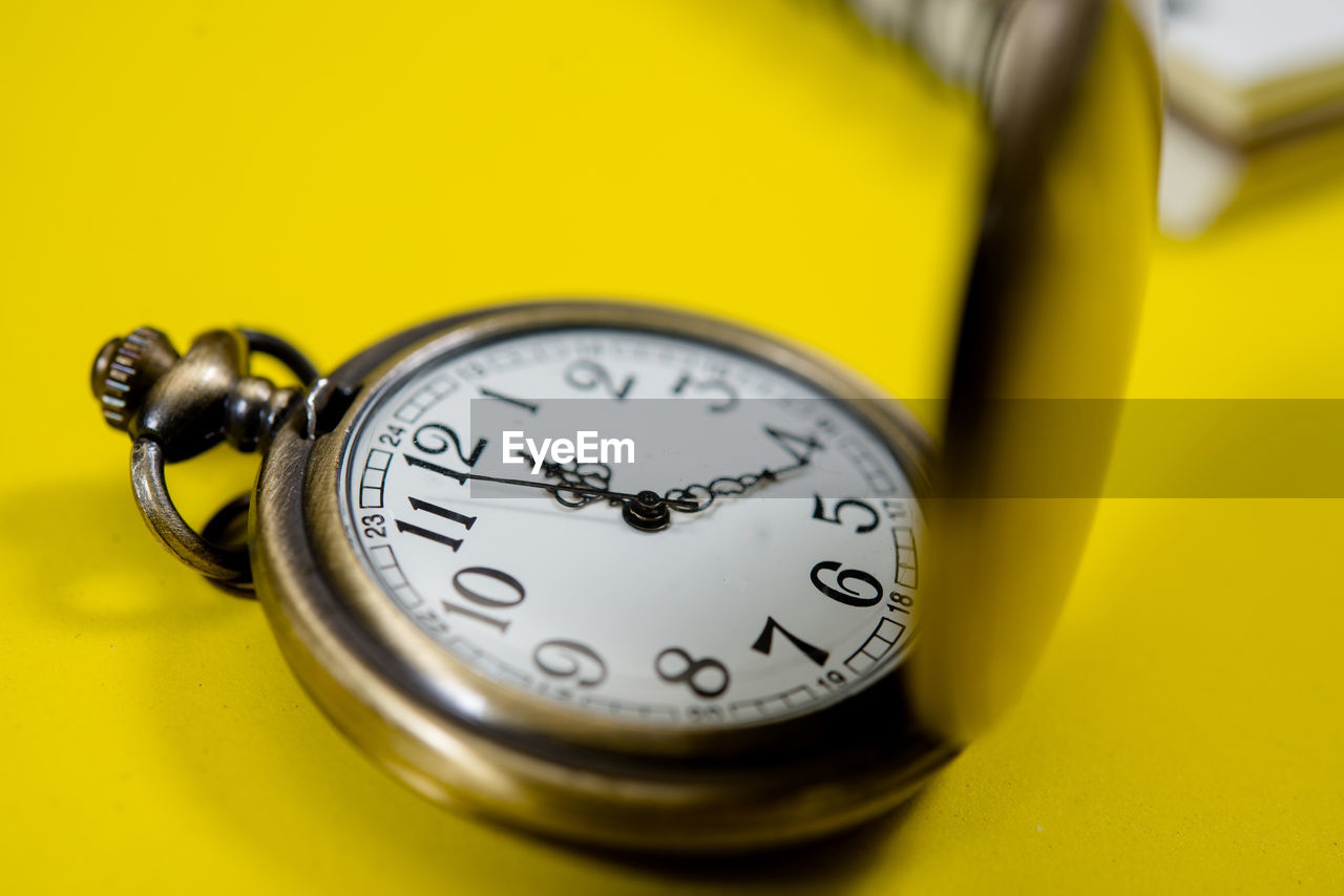 HIGH ANGLE VIEW OF CLOCK ON YELLOW WALL