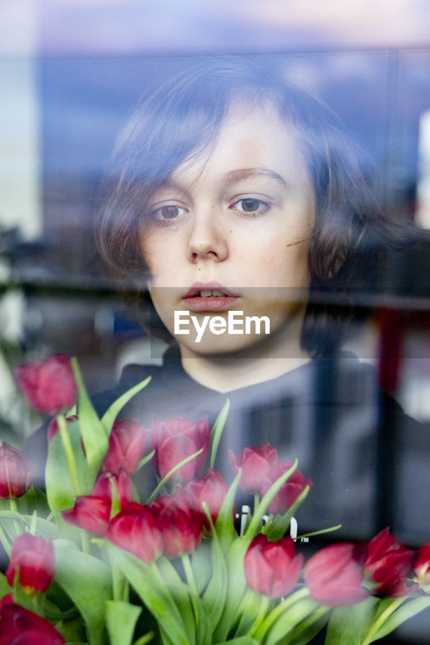 Portrait of a kid with red tulips