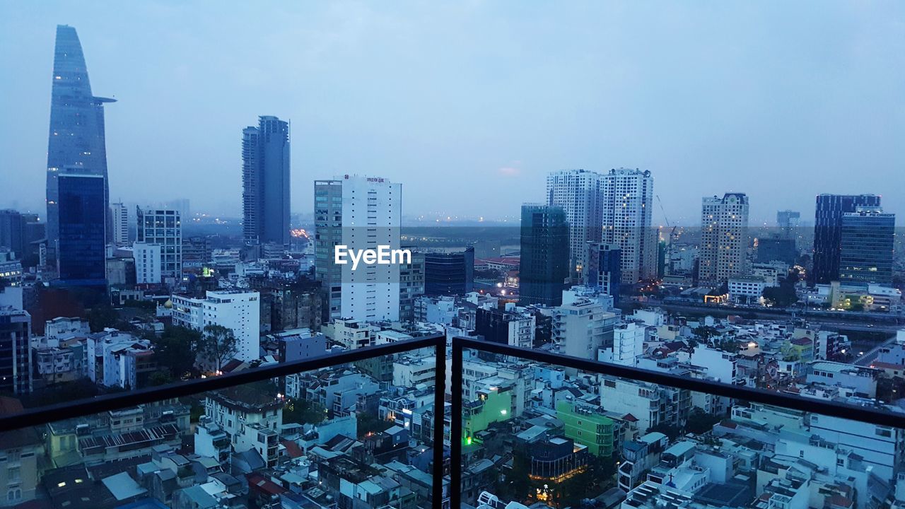 HIGH ANGLE VIEW OF ILLUMINATED BUILDINGS AGAINST SKY