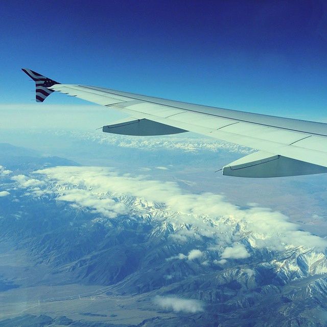LOW ANGLE VIEW OF AIRPLANE WING OVER LANDSCAPE