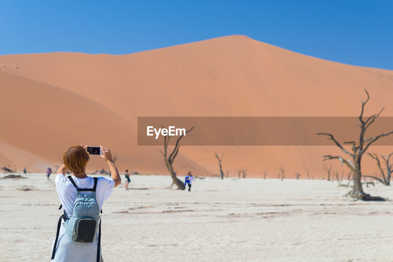 Person photographing in desert