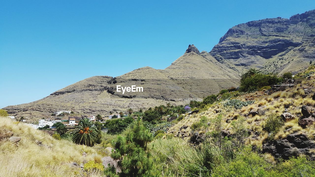 Scenic view of mountains against clear blue sky