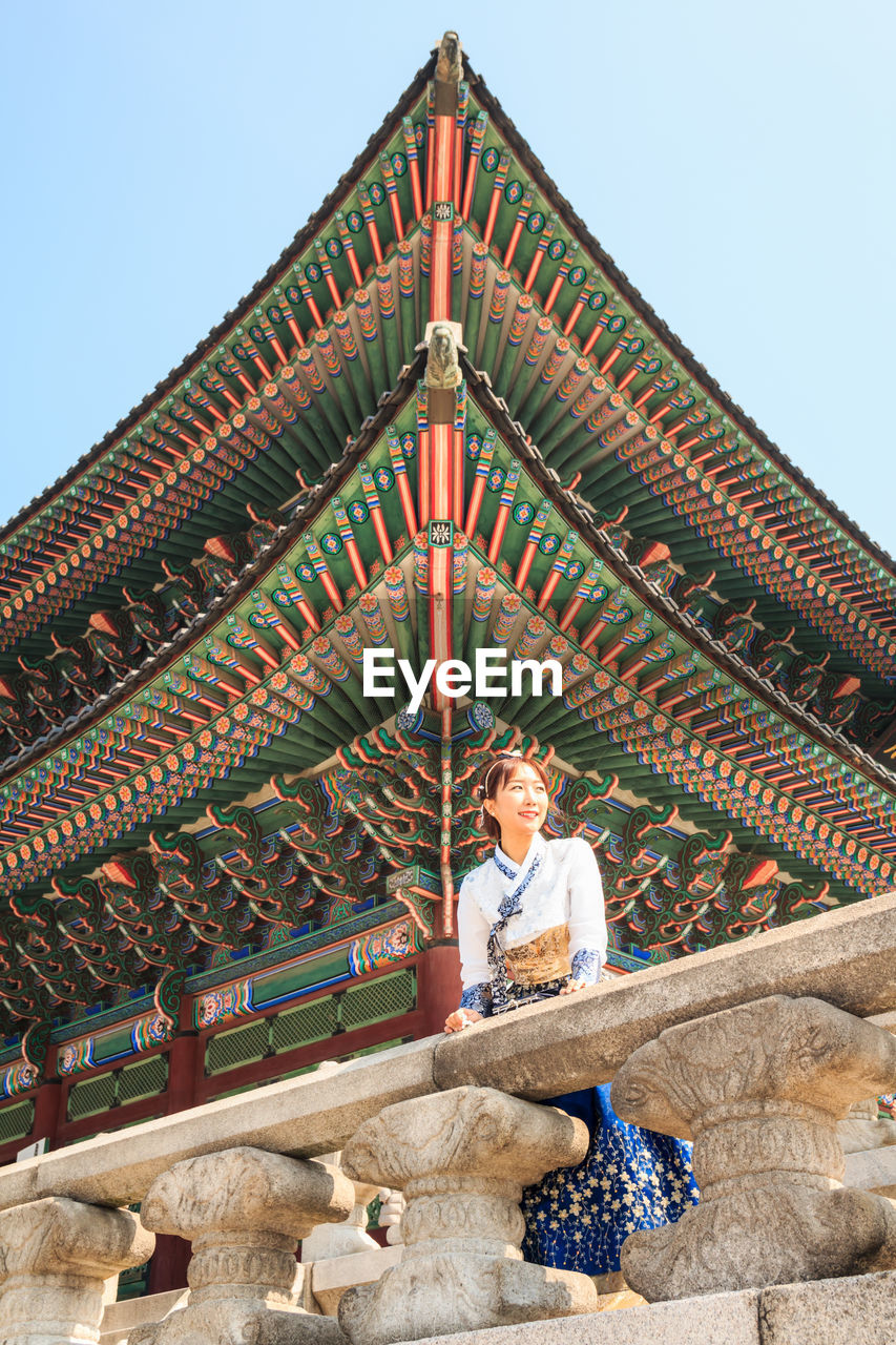 Low angle view of woman standing against temple