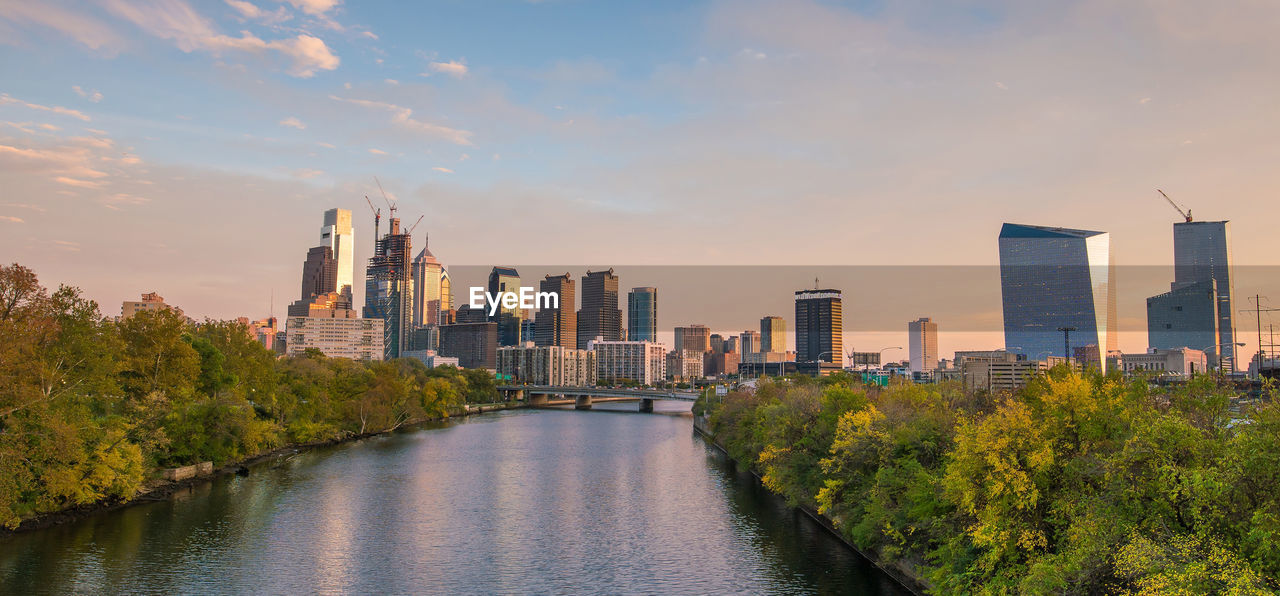 river amidst buildings against sky during sunset