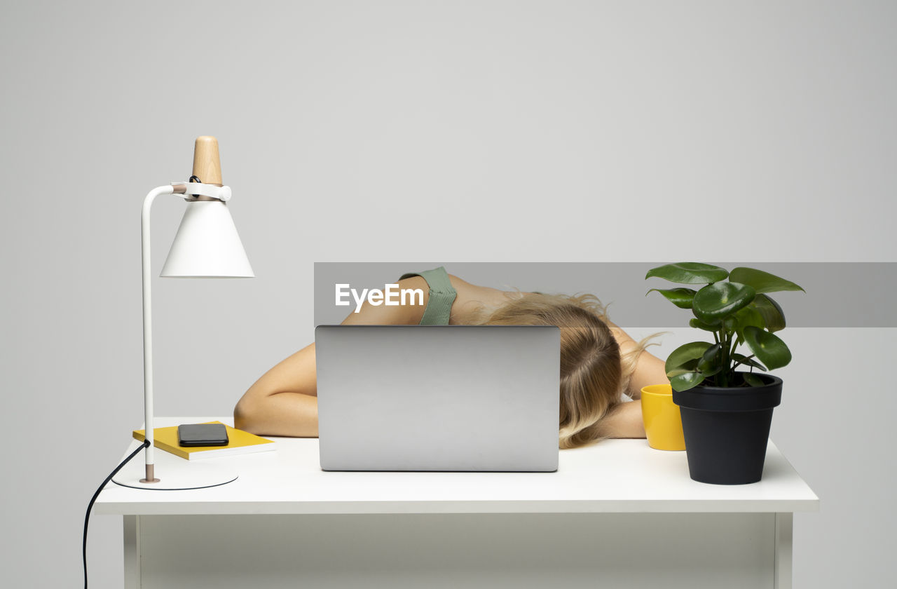 digital composite image of woman using mobile phone on table against white background