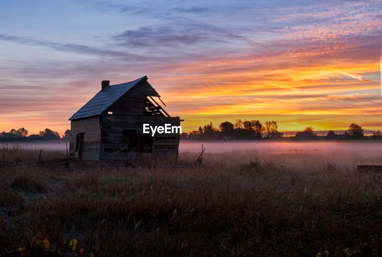 House on field against sky during sunset