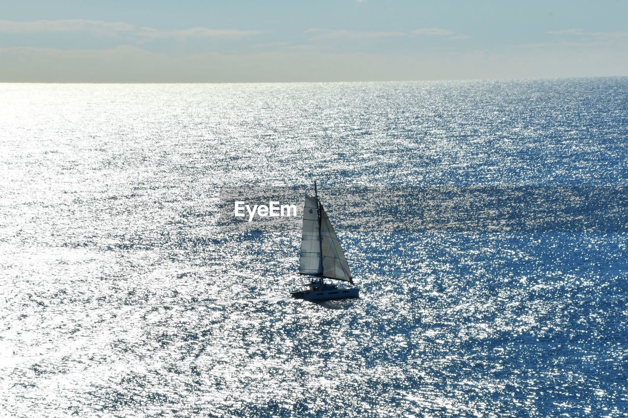 Sailboat sailing on sea against sky