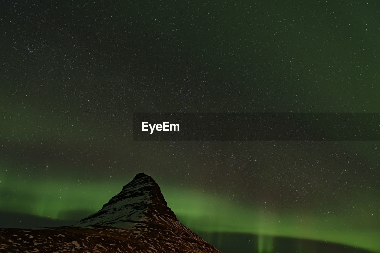 Low angle view of aurora borealis at night during winter