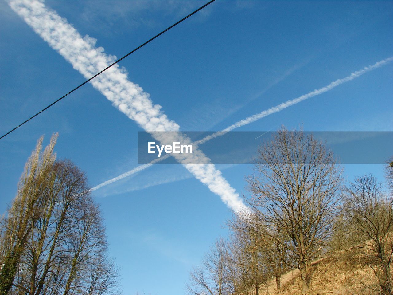 Low angle view of vapor trail against blue sky