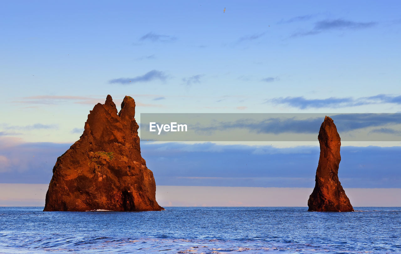 ROCK FORMATIONS ON SEA AGAINST SKY