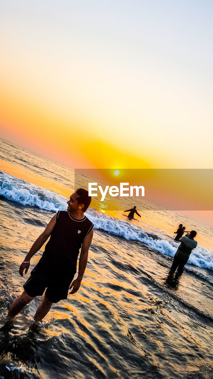 MAN ON BEACH DURING SUNSET