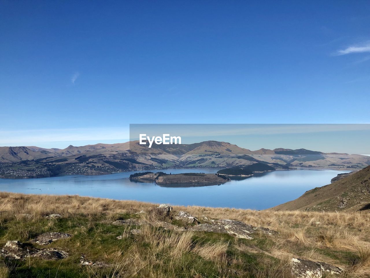 lake, scenics - nature, water, sky, mountain, environment, landscape, beauty in nature, nature, wilderness, reservoir, blue, tranquility, land, tranquil scene, highland, no people, body of water, travel destinations, travel, coast, day, non-urban scene, plant, mountain range, outdoors, clear sky, plateau, cloud, crater lake, grass, tourism, beach, ridge