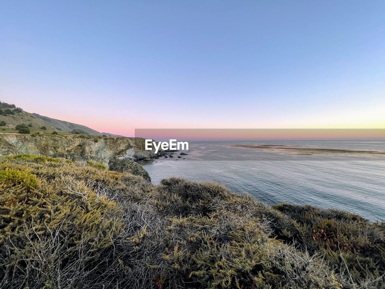 Scenic view of sea against clear sky during sunset