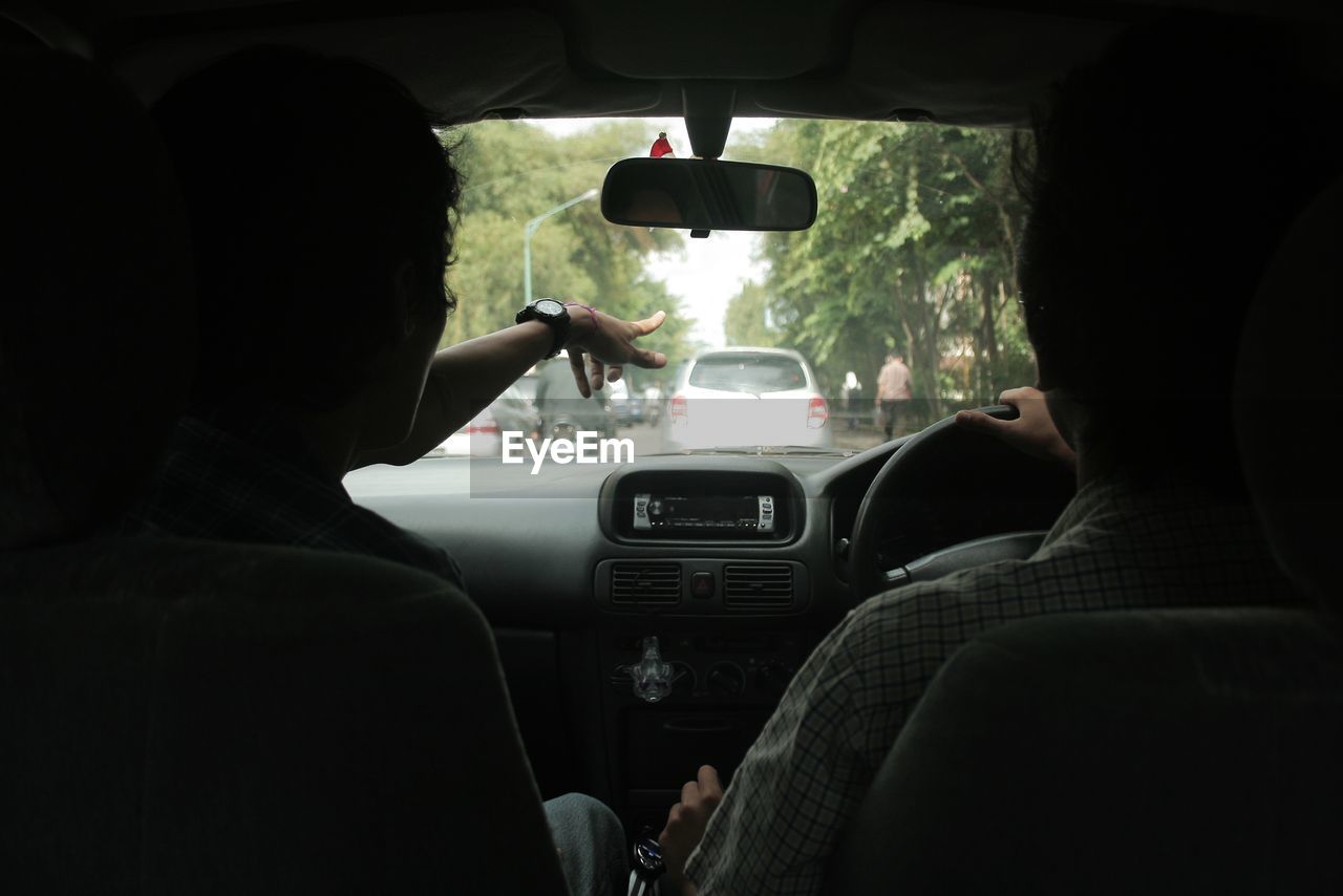 REAR VIEW OF MAN TRAVELING IN BUS