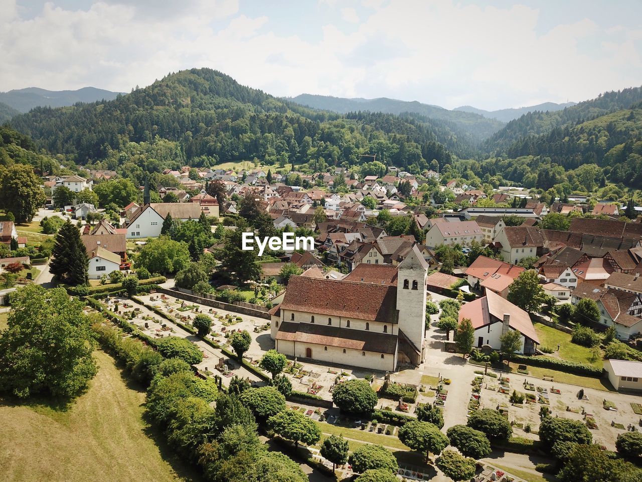 HIGH ANGLE VIEW OF TOWNSCAPE AND TREES AGAINST SKY