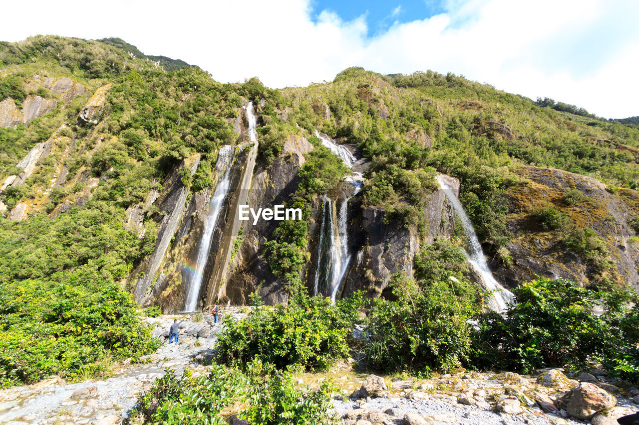SCENIC VIEW OF WATERFALL AGAINST SKY
