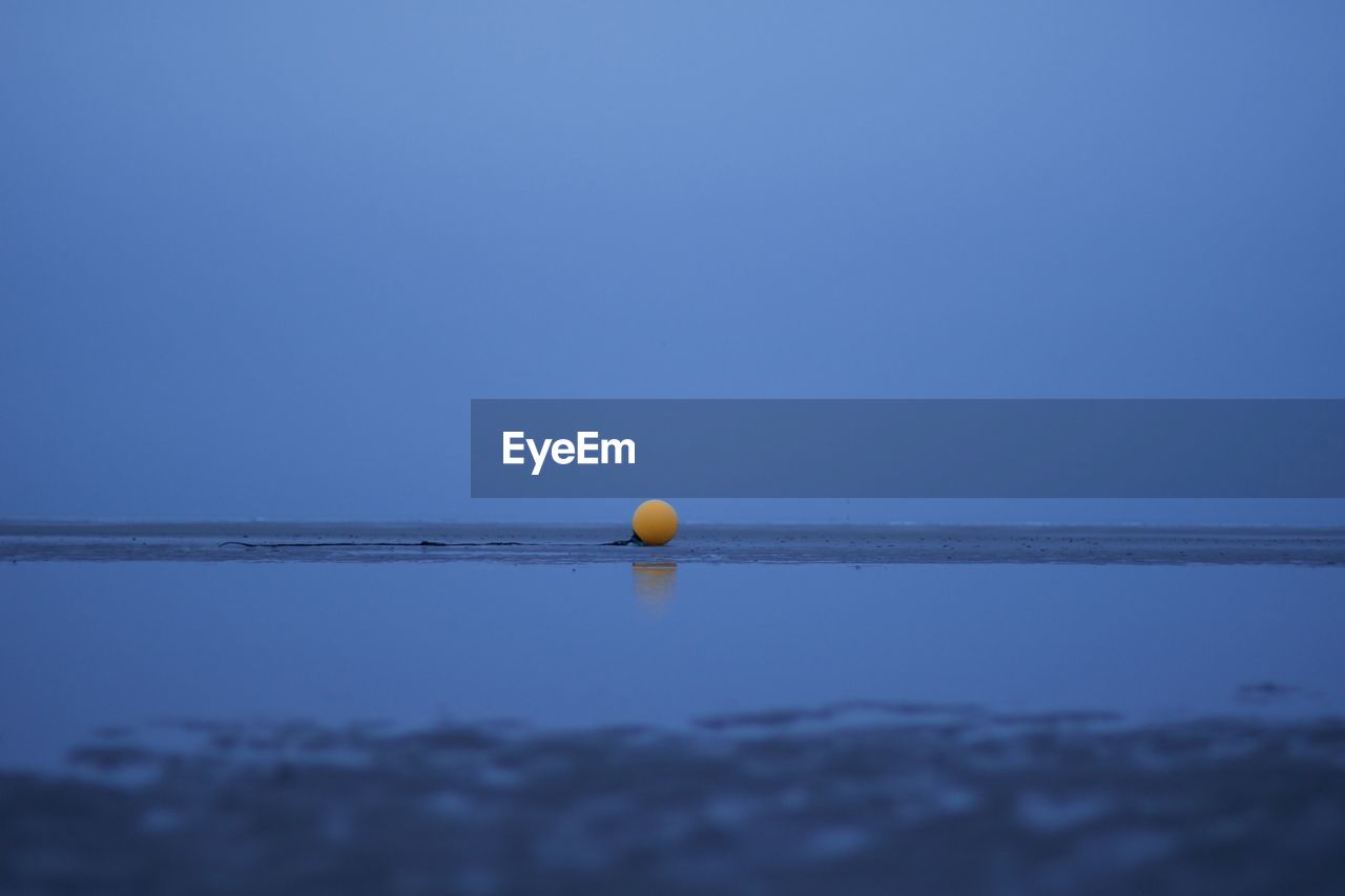 BALL FLOATING ON SEA AGAINST CLEAR SKY