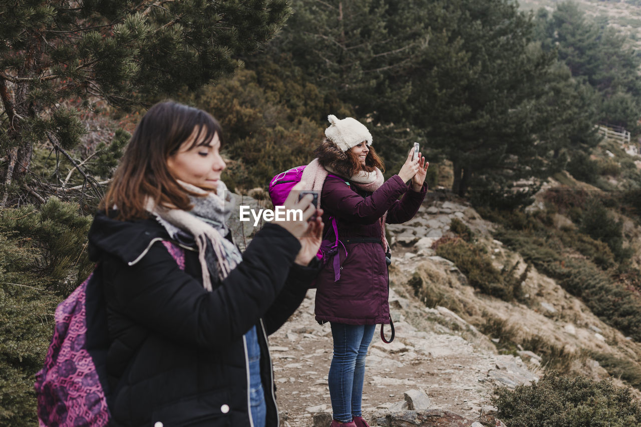 Full length of females photographing while standing on mountain