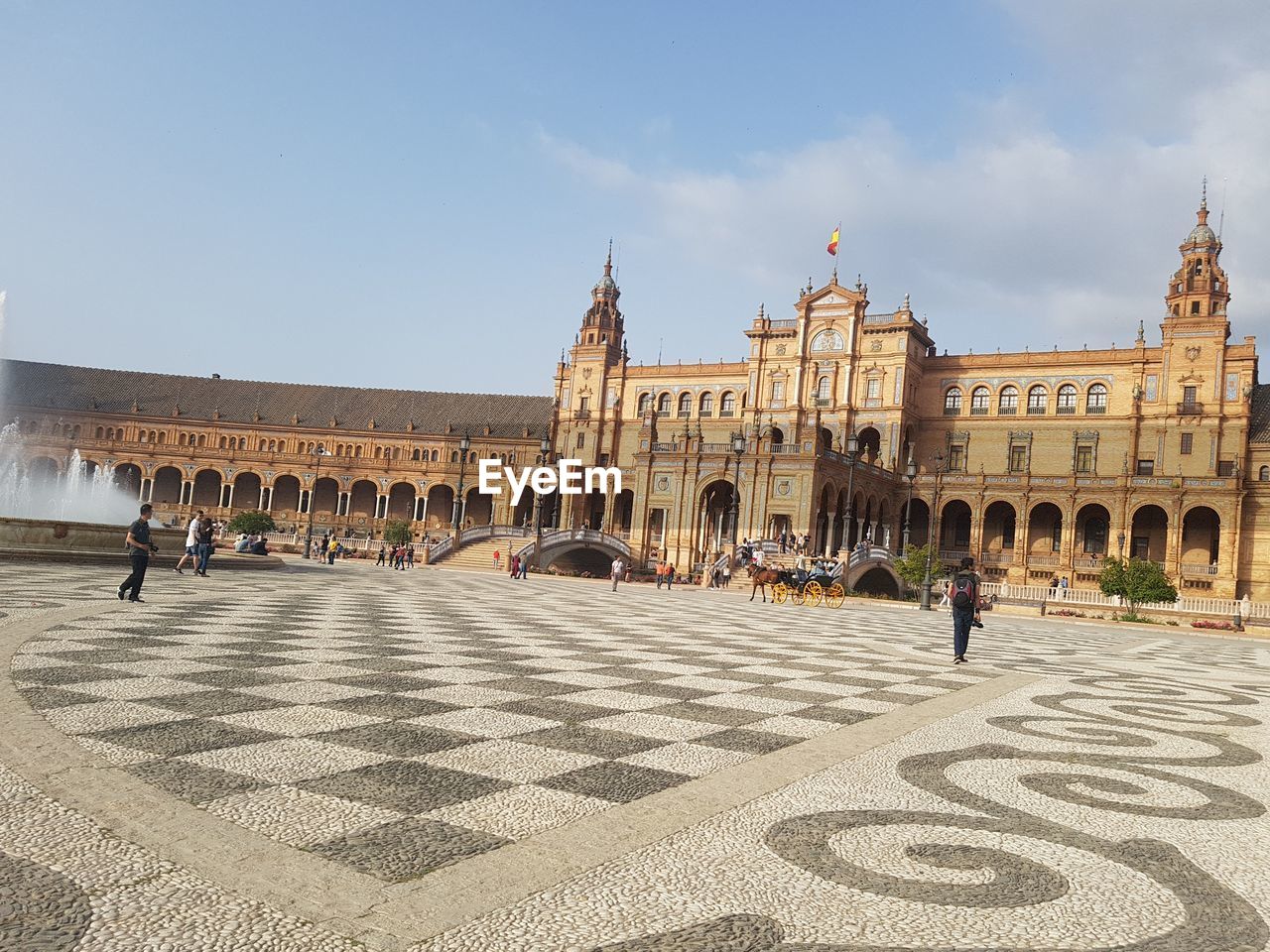 People in front of historical building against sky 