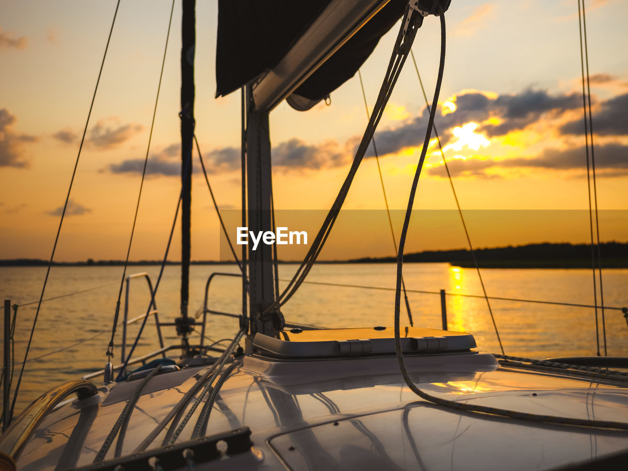 Sailing yacht bow in sunset light, sailing on a lake