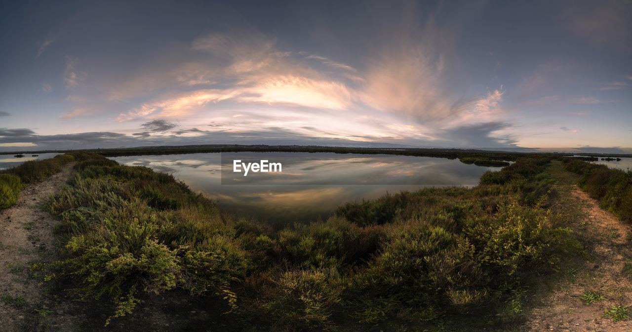 sky, nature, cloud, water, environment, morning, reflection, scenics - nature, landscape, beauty in nature, plant, land, coast, sea, horizon, sunlight, no people, tranquility, sunrise, dawn, hill, tree, tranquil scene, travel destinations, outdoors, travel, dramatic sky, beach, non-urban scene, tourism, cloudscape, wilderness, grass, sun, reservoir