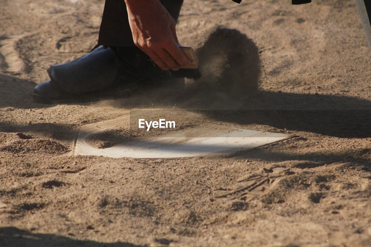 Low section of man cleaning home base during match