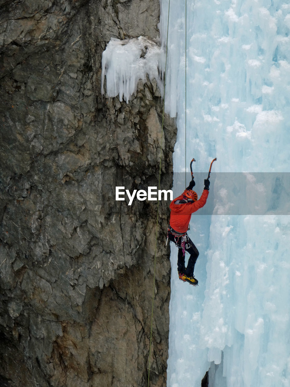 Man climbing on snow covered mountain