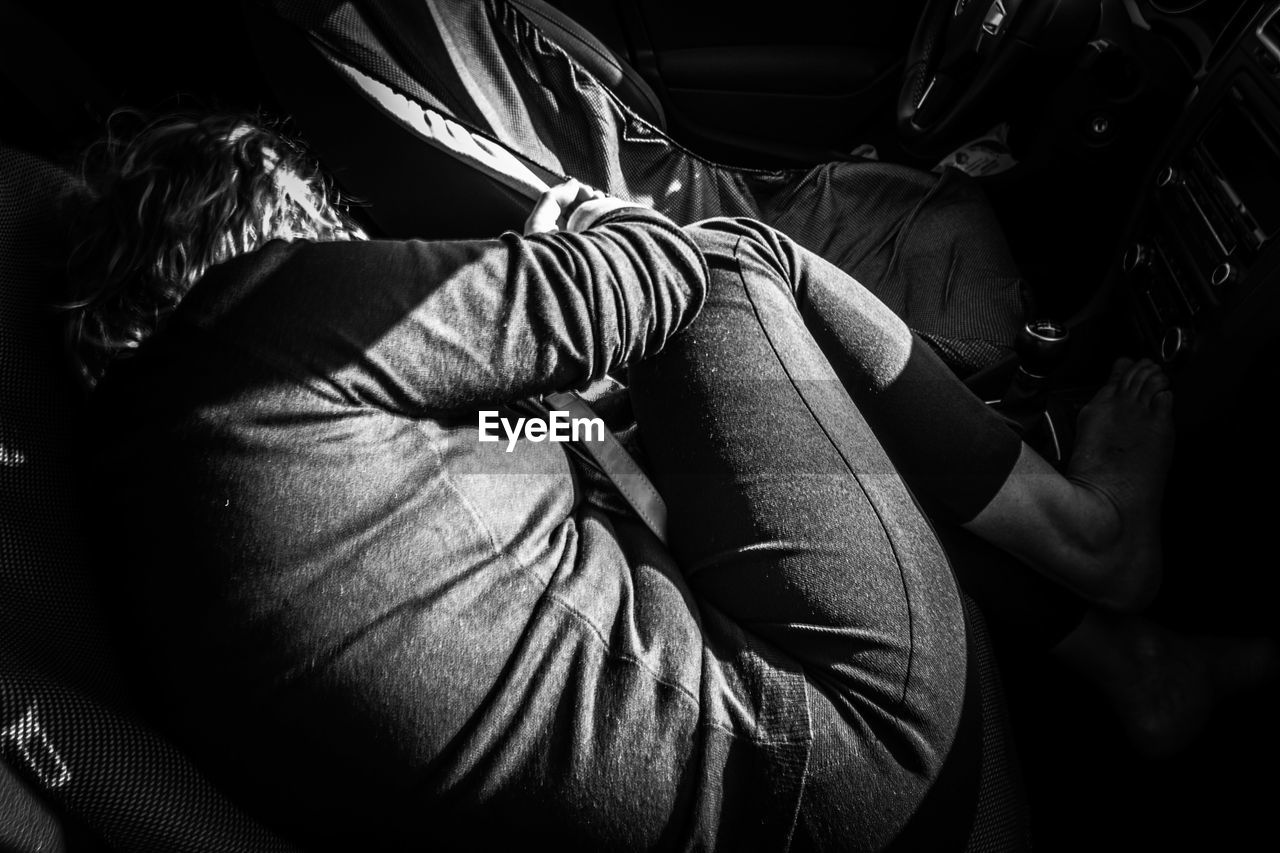 High angle view of woman sleeping in car