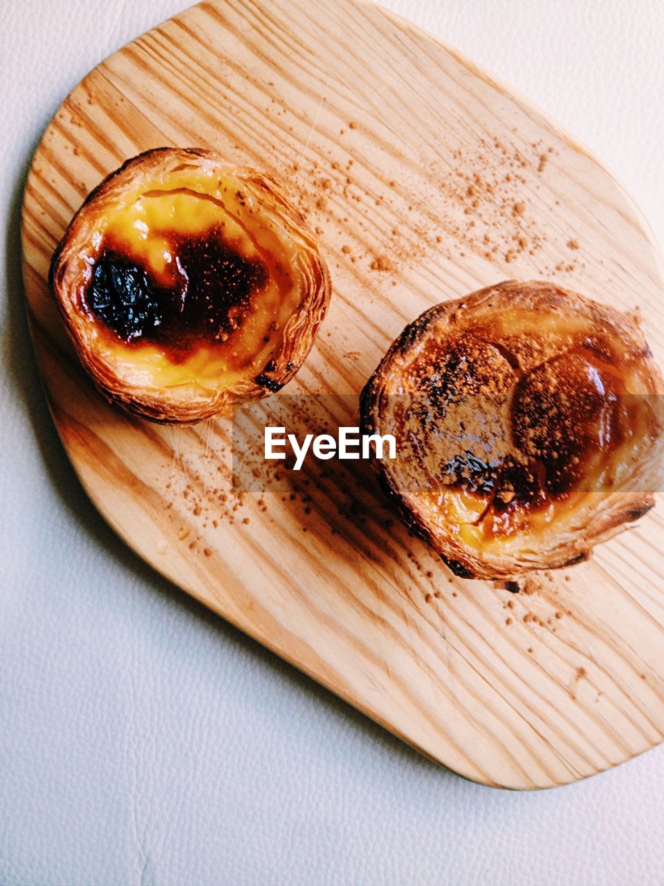 High angle view of pastel de nata on cutting board at table