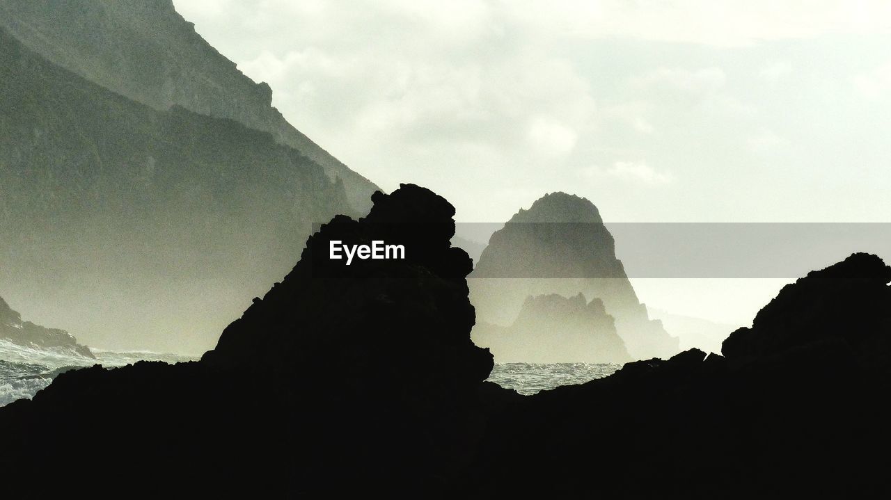 SCENIC VIEW OF ROCK FORMATION IN SEA AGAINST SKY