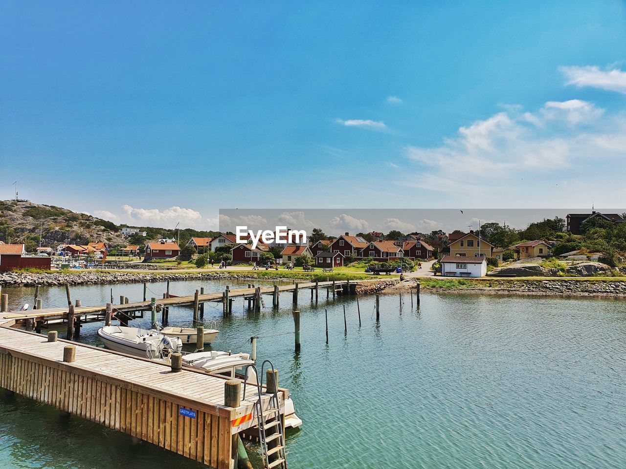 Town by river against sky in city