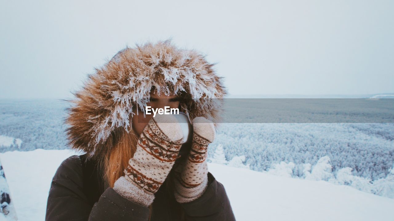 Close-up of woman drinking during winter