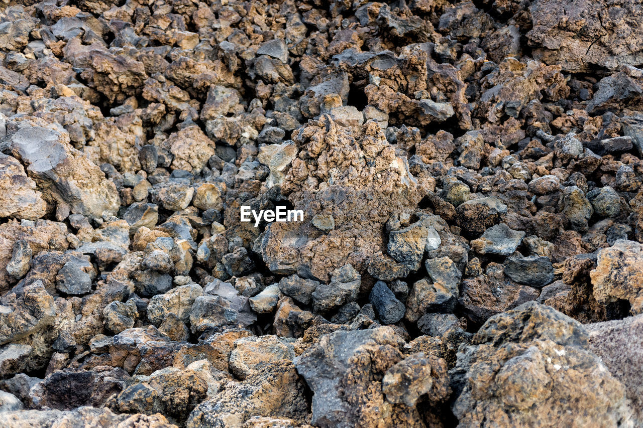 full frame, soil, backgrounds, rock, nature, no people, day, land, textured, high angle view, sunlight, outdoors, gravel, rubble, geology, abundance, beach, stone, close-up, rough, pattern