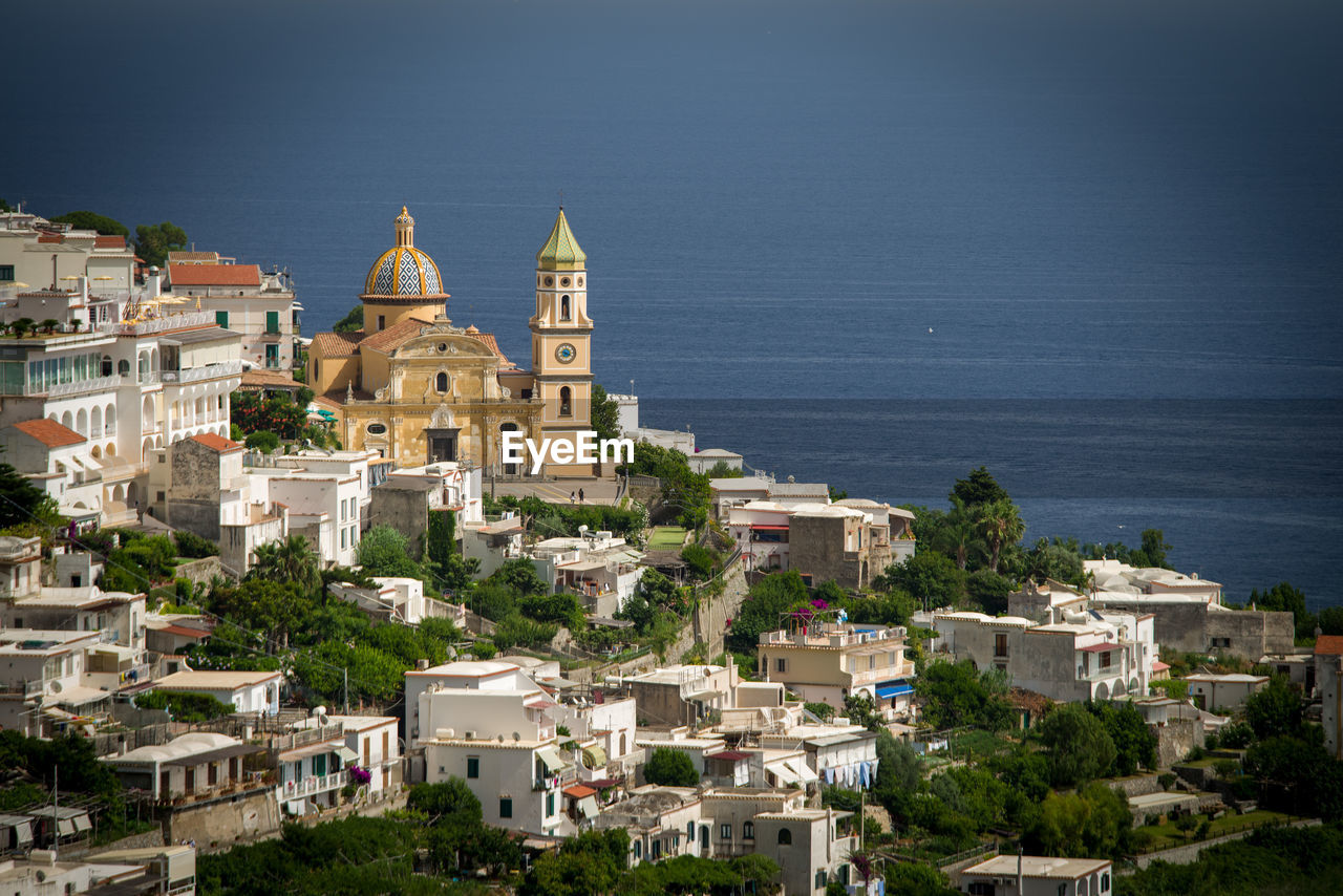 architecture, building exterior, built structure, building, town, city, travel destinations, water, religion, nature, sea, high angle view, cityscape, place of worship, travel, land, sky, residential district, belief, coast, tourism, history, no people, the past, aerial photography, spirituality, house, tree, dome, tower, old, outdoors, plant, landmark, community, roof, vacation, environment, beach, scenics - nature, day, landscape, clear sky, beauty in nature, village, hill, medieval, horizon, blue, sunlight