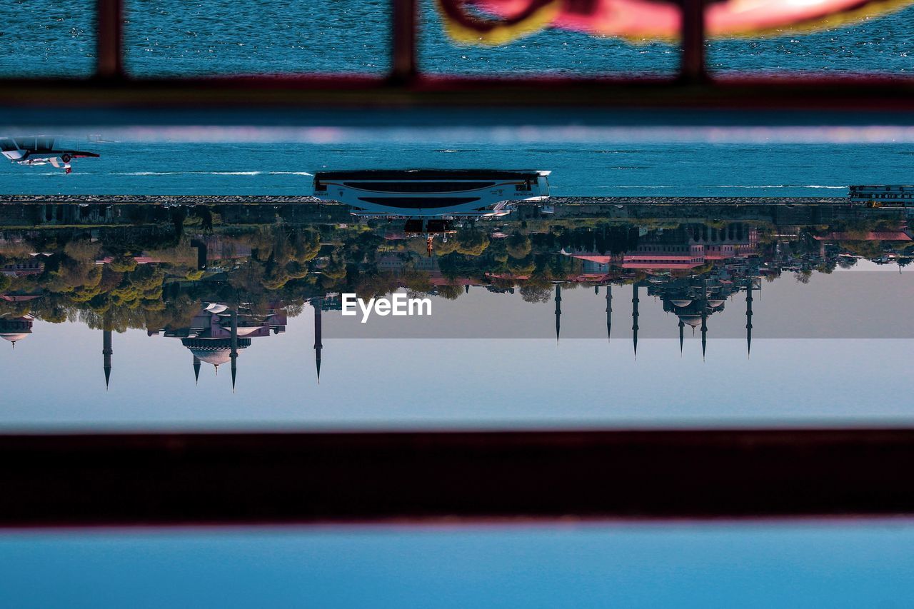 Reflection of building in lake against blue sky