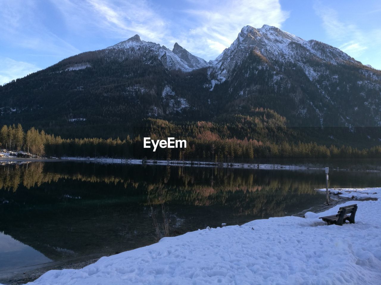 Scenic view of lake by snowcapped mountains against sky