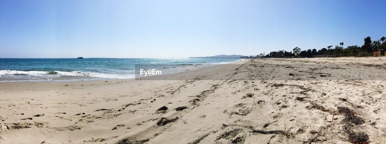 Scenic view of beach against clear blue sky