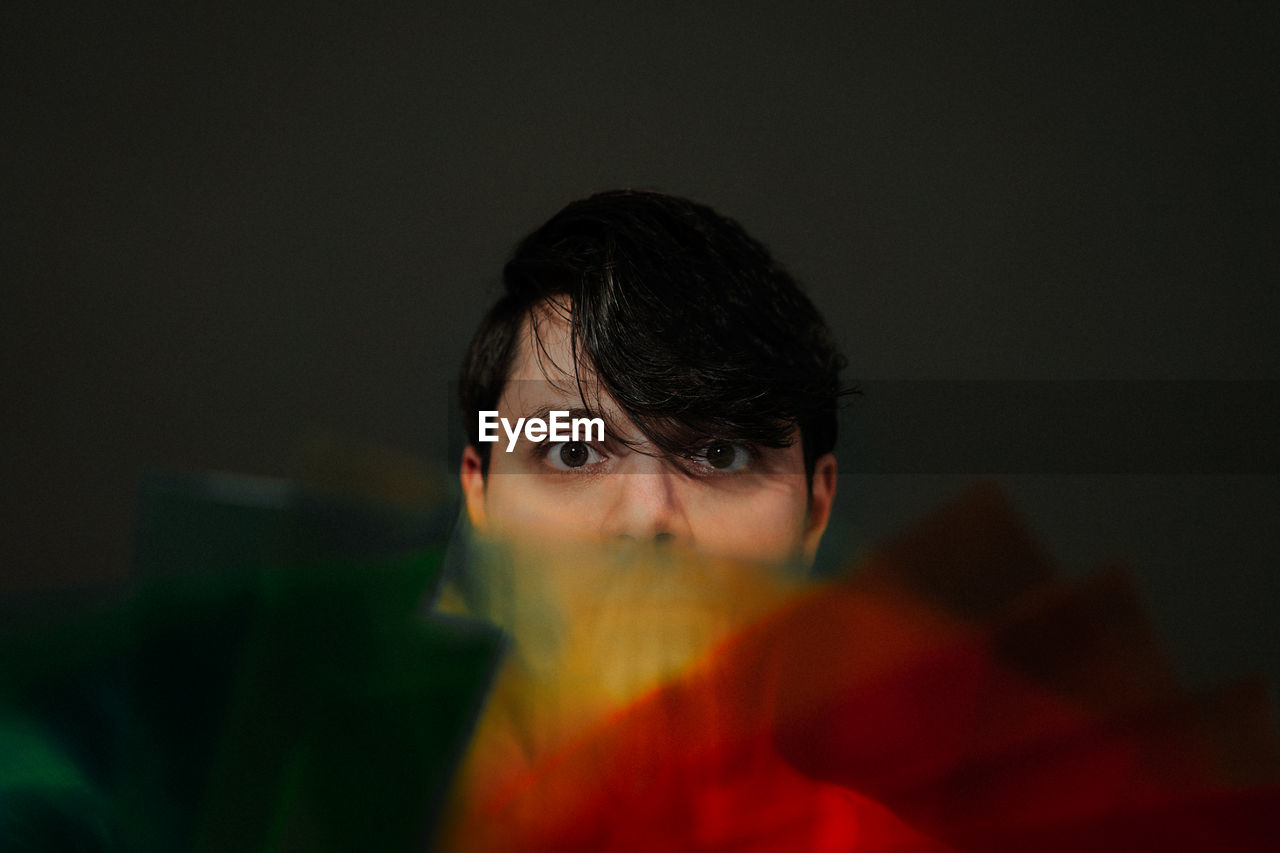 Close-up portrait of man against black background