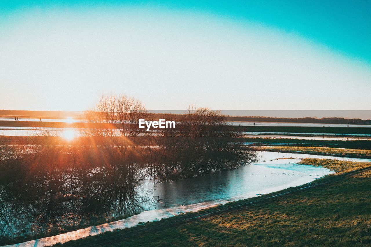 SCENIC VIEW OF FROZEN LAKE AGAINST CLEAR SKY