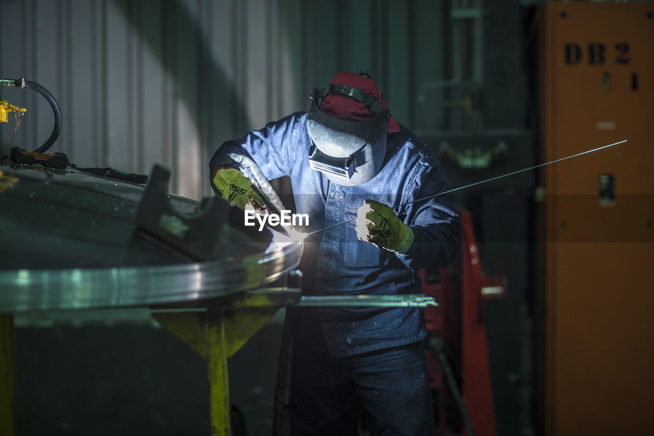 Worker welding in factory