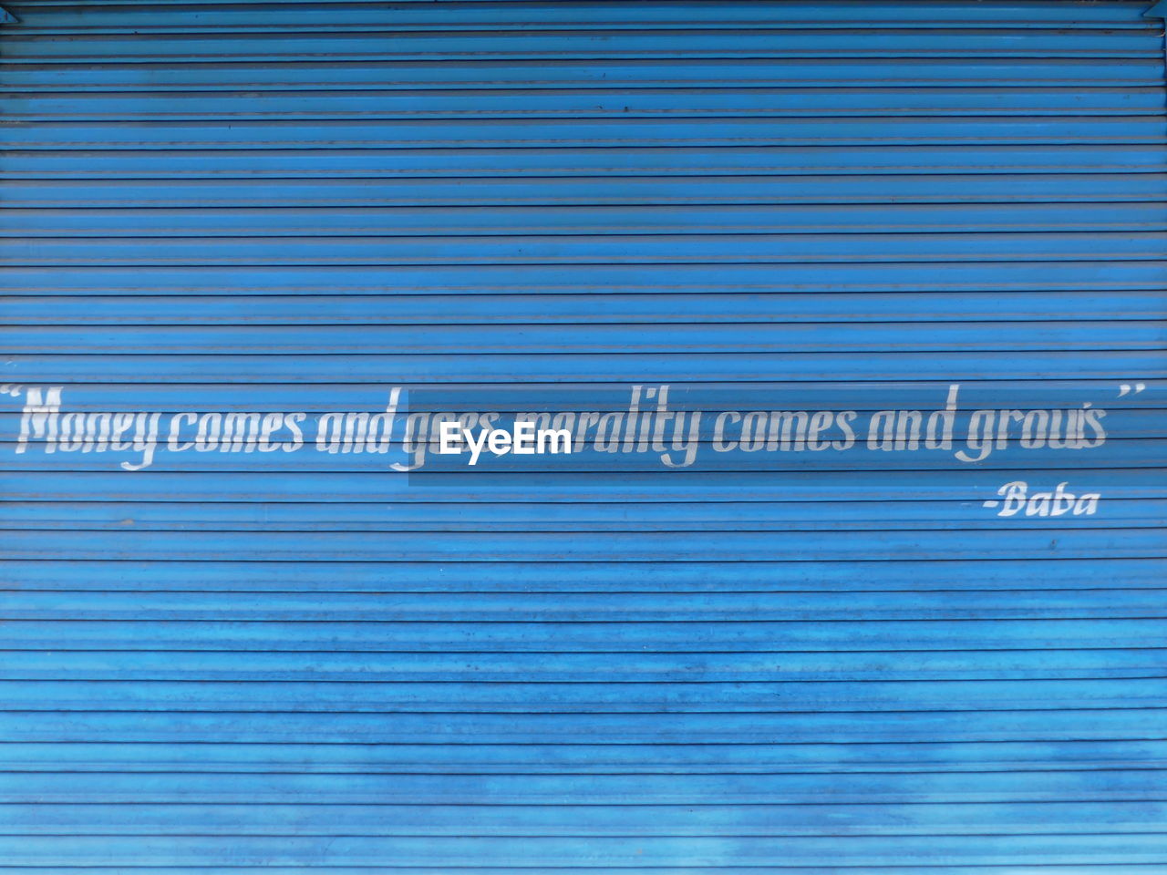 CLOSE-UP OF TEXT WRITTEN ON BLUE WALL