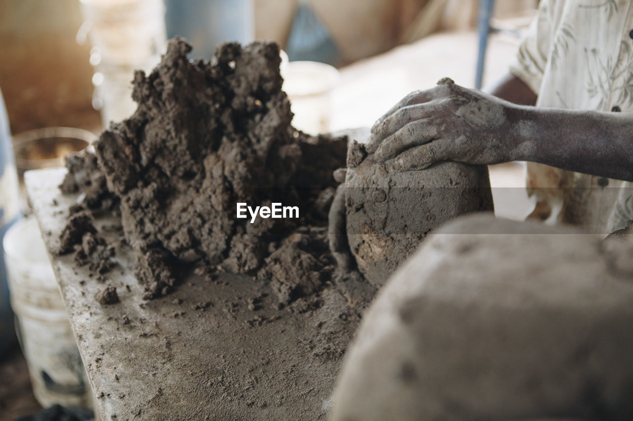 Cropped image of craftsperson molding clay