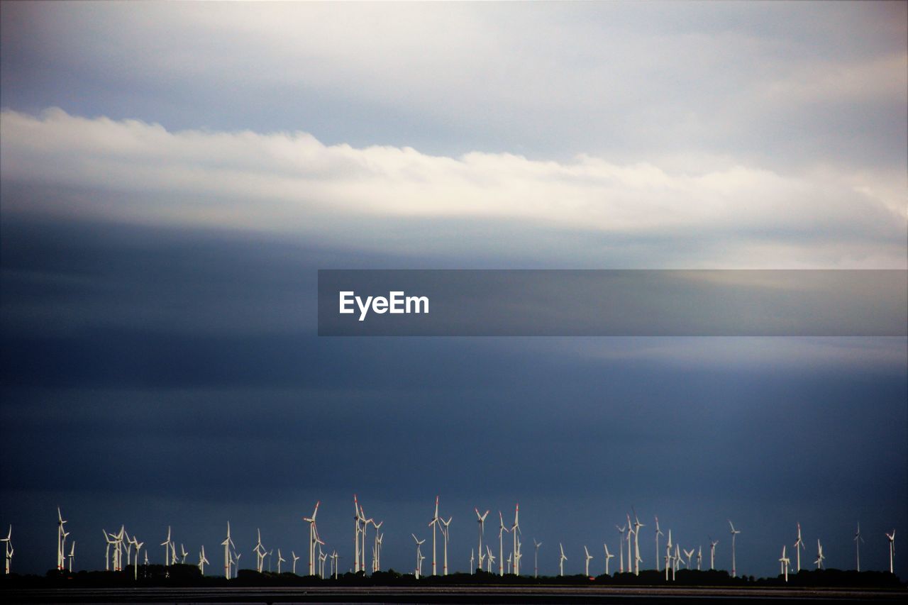 Panoramic view of wind turbines against sky