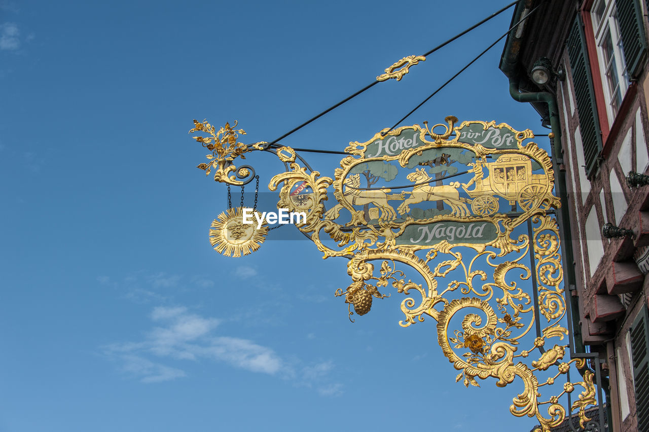 LOW ANGLE VIEW OF DECORATION AGAINST BLUE SKY