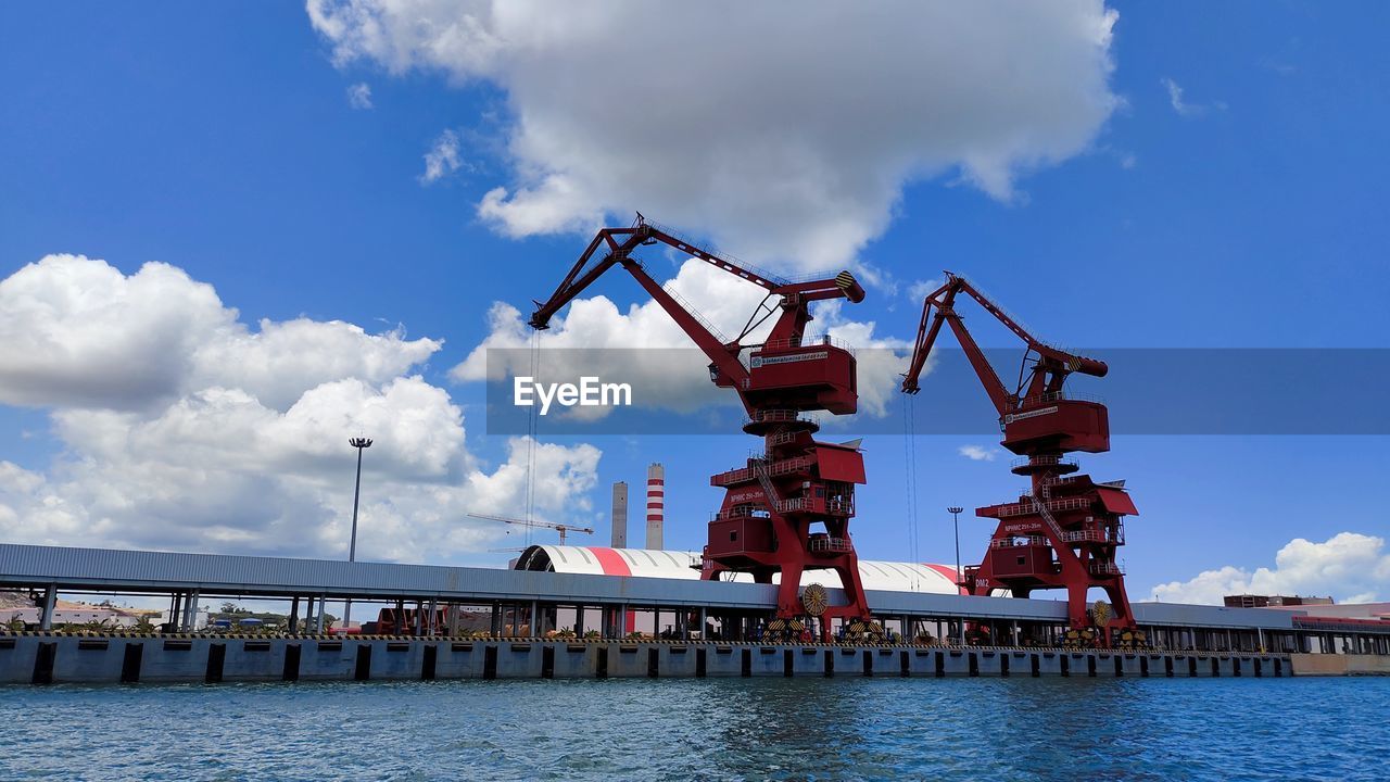 water, sky, cloud, industry, crane - construction machinery, machinery, architecture, pier, transportation, nature, vehicle, business, commercial dock, freight transportation, built structure, unloading, shipping, transport, blue, business finance and industry, harbor, sea, outdoors, no people, loading, nautical vessel, waterfront, mode of transportation, day, construction industry, bridge, container