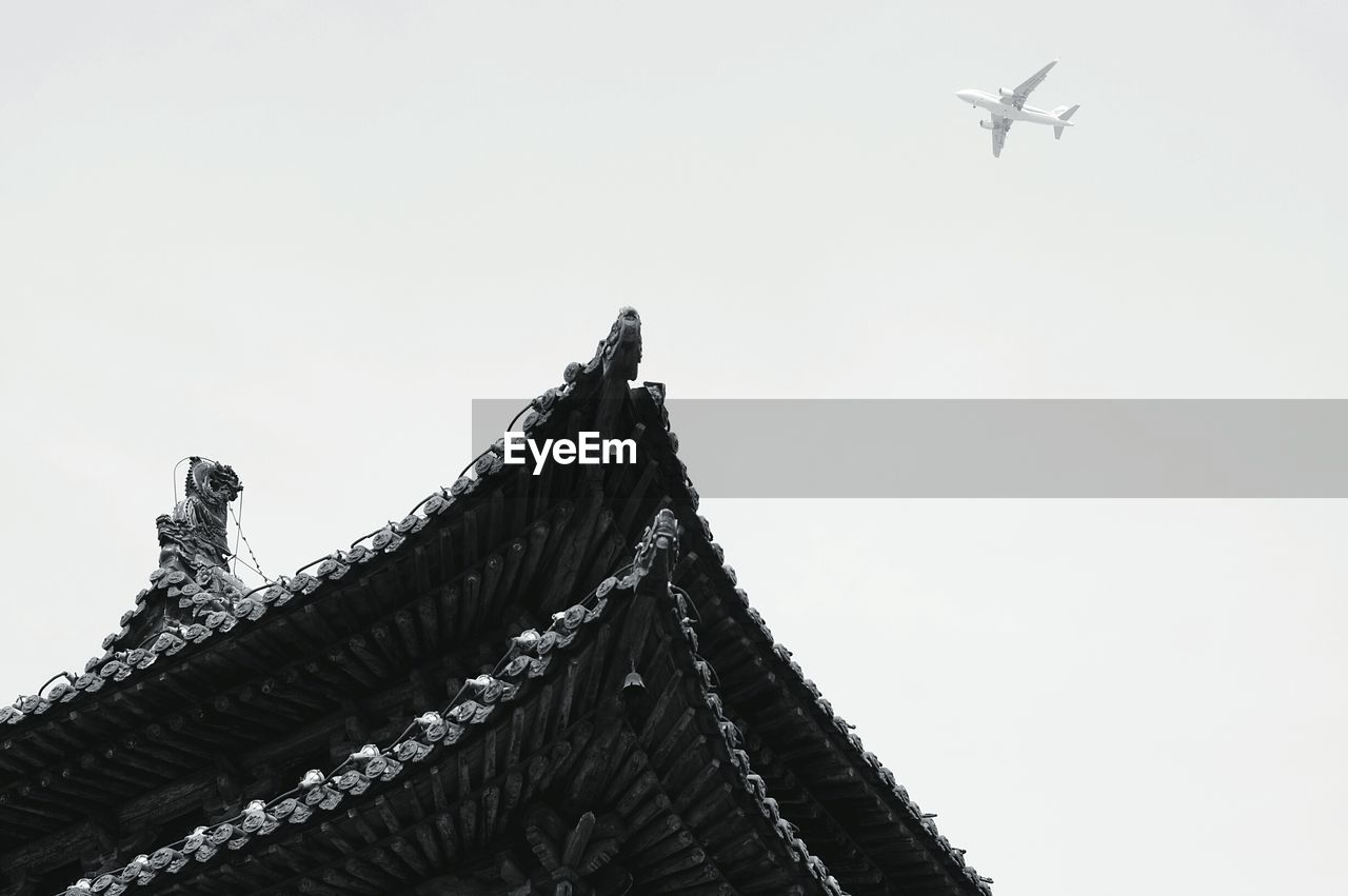 LOW ANGLE VIEW OF AIRPLANE FLYING OVER CASTLE