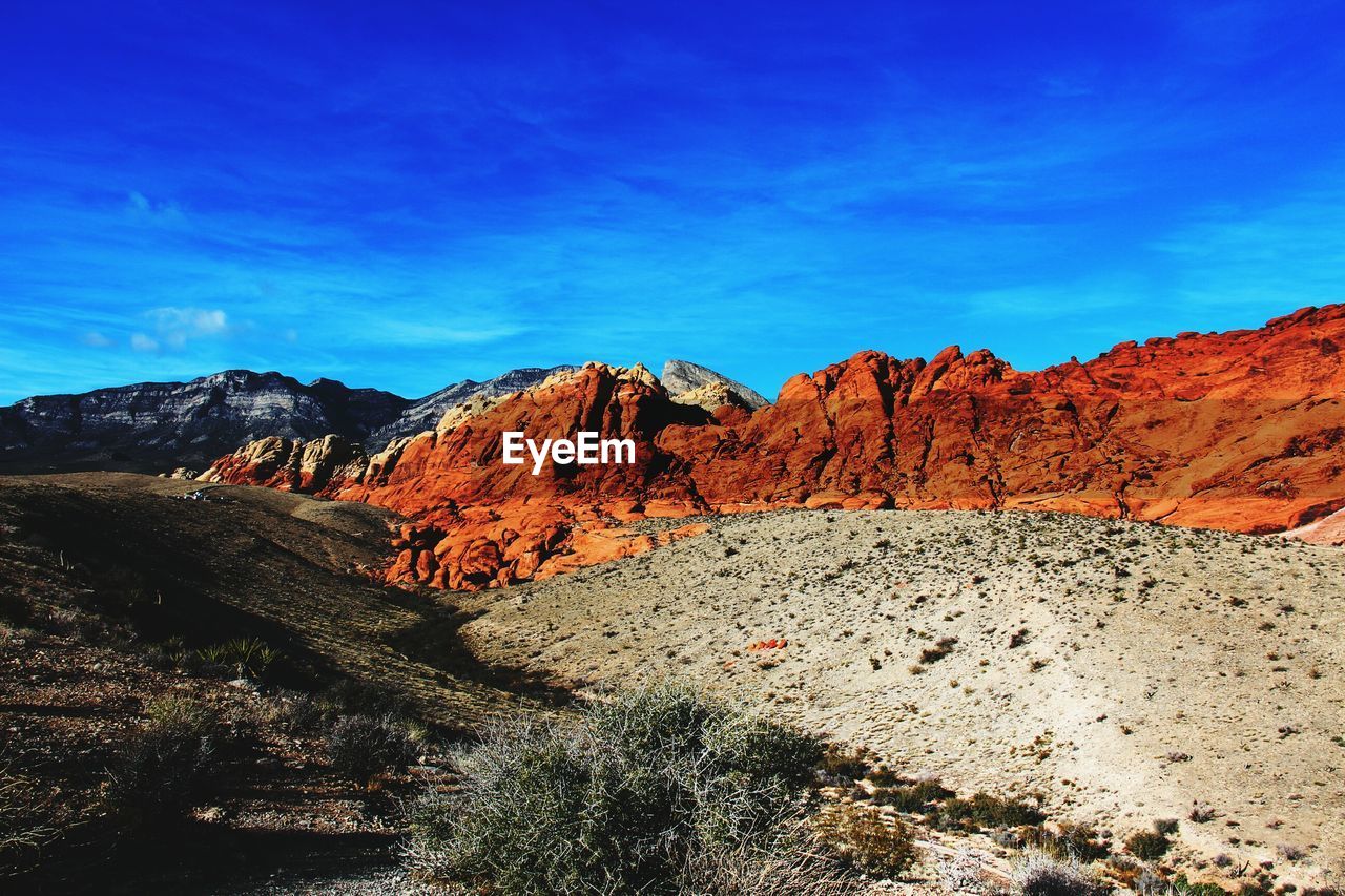 Scenic view of mountains against blue sky