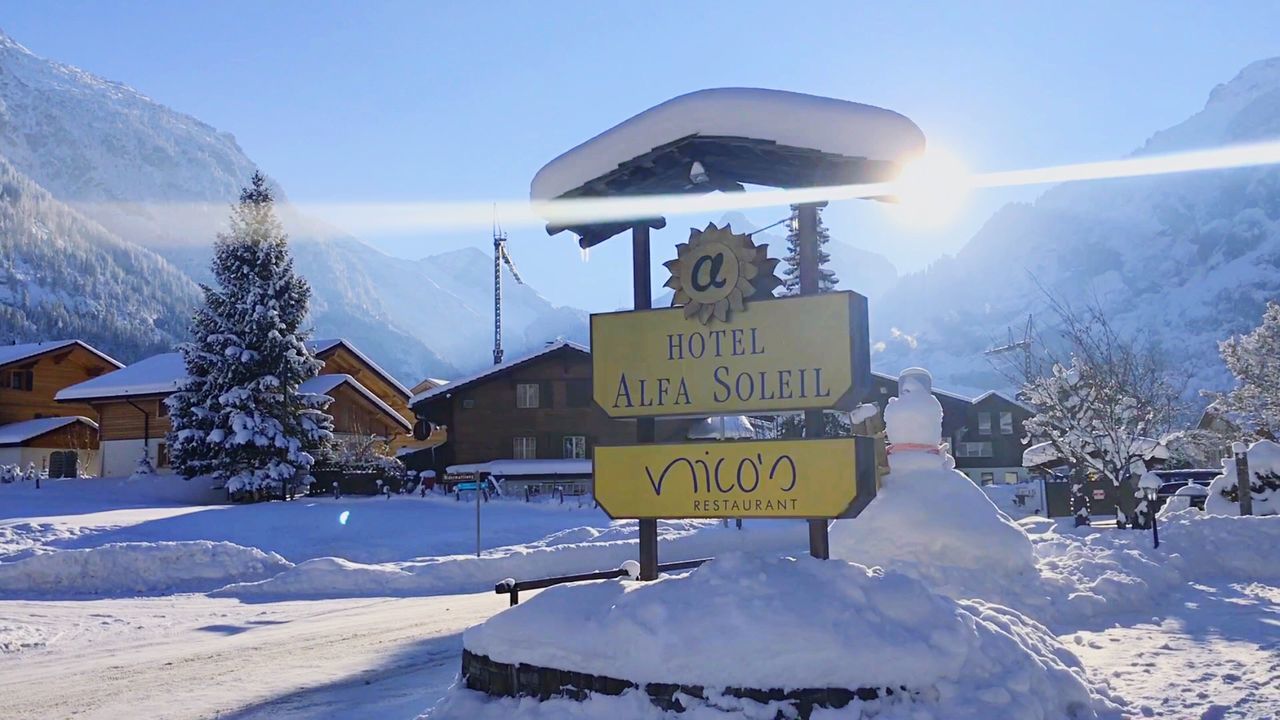 Information sign on snowcapped mountain against sky