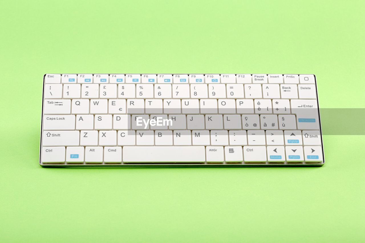 High angle view of computer keyboard against green background